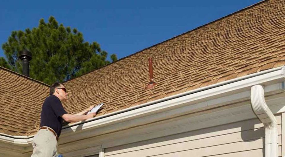 Envision Property Maintenance employee assessing a roof to repair